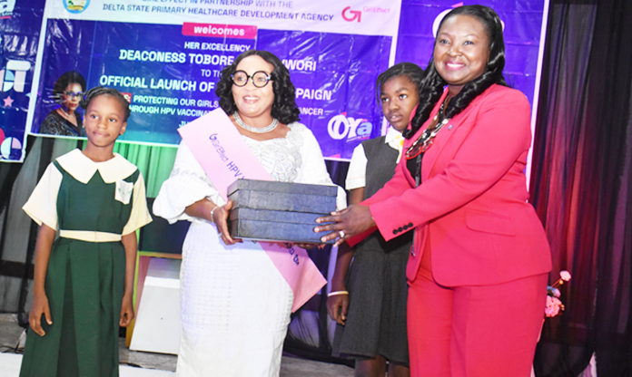 Wife of Delta State Governor, Deaconess Tobore Oborevwori and Founder,” You Matter Charity Foundation,” represented by wife of Deputy Governor, Ezinne Catherine Onyeme (middle), receiving a Souvenir from the Country Director, Girl Effect, Nigeria, Mrs Boladale Akin-Kolapo (right), while Praise Michael, pupil of Poshville International School (left), and Agbonta Janice, pupil of Government Primary School, Asaba, watch during the official flag-off of ‘Effect Oya Campaign’ launch in Government House, Asaba, on Wednesday.