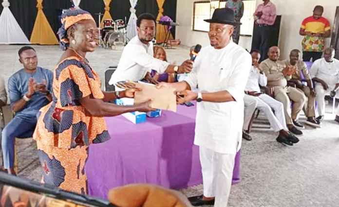 Hon. Warri Voke Friday presenting the cash package to one of the beneficiaries of his empowerment programme.