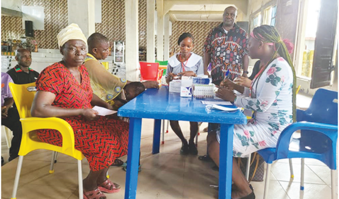 Sponsor of the medical outreach and an APC chieftain, Rev Tony Ogugu (standing) with beneficiaries of his free medical outreach at Agbarho.