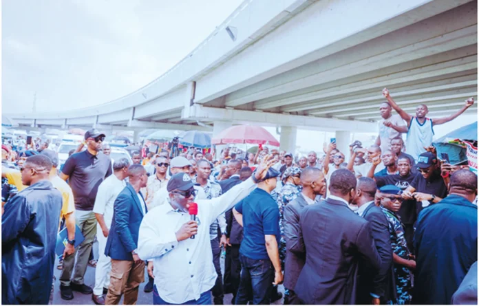 Delta State Governor, Rt. Hon. Sheriff Oborevwori, acknowledging cheers from traders and residents at Enerhen Junction shortly after driving through the DSC Roundabout and Enerhen Junction Flyovers, yesterday,. Pix: SAMUEL JIBUNOR
